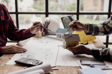 İnşaat mühendislerinden oluşan bir ekip bir bina ya da inşaat mimarisi planlıyor. Takım liderliği ya da bir tasarımcının bir toplantıda kat planı fikirlerini tartışması ya da tartışması..