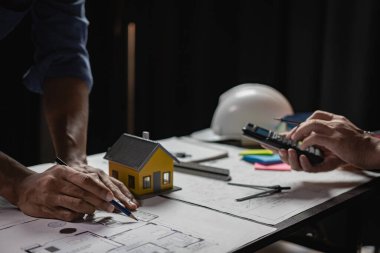 Bina tasarımı, inşaat ve yapı projesi toplantısı mühendisi veya mimarı ortaklarla yakın çekim projeleri için çizmek ve dizüstü bilgisayarı kullanarak projeye işaret eden mühendis