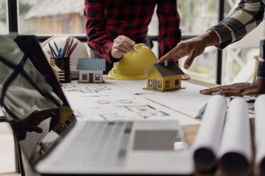 Bina tasarımı, inşaat ve yapı projesi toplantısı mühendisi veya mimarı ortaklarla yakın çekim projeleri için çizmek ve dizüstü bilgisayarı kullanarak projeye işaret eden mühendis