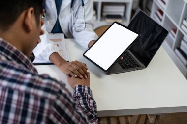 Kadın doktor, profesyonel tıbbi danışmanlık için klinikte ağrı dayanıklılığı hakkında sorular sorarken hastanın kolunu muayene ediyor. Mutlu adam doktorla gelecekteki tedavisi hakkında konuşuyor..