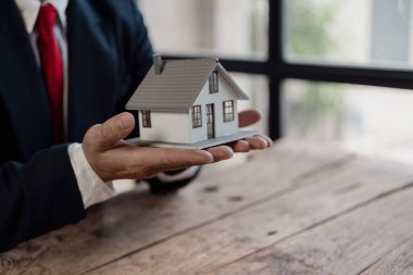 Ofis koruma sigortasında mali yatırımlar üzerinde çalışan işadamı koruma ve bakım için ev, gayrimenkul satışları konsepti, yakın çekim