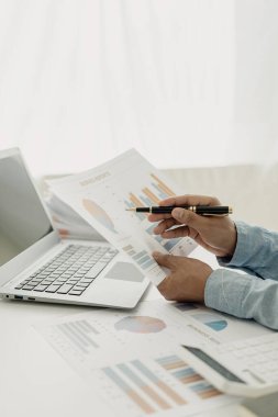 İş adamı analiz planı muhasebeci mali raporları hesaplar. Bilgisayarda grafikler, iş konseptleri, finans ve muhasebe, bütçe ve kredi kağıtları bulunur. Yakın plan, dikey bir fotoğraf çekin..