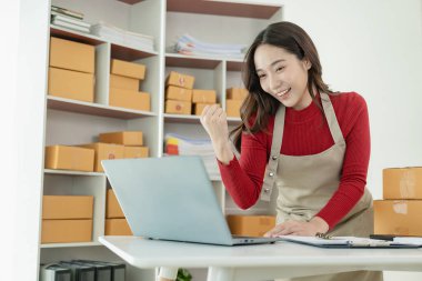 İnternet üzerinden müşterilere, KME 'ye, küçük işletme girişimcilerine, çevrimiçi KOBİ iş konseptine satacak paketleri hazırlamak ve hazırlamak için önlük ve kutu kullanan serbest çalışan Asyalı kadınların listesi.