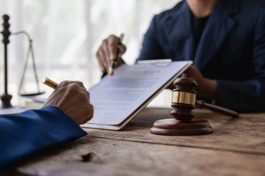 Yargıç Çekiç ve Adalet Avukatı, hukuk bürosunda takım toplantısı yapıyor. Erkek işadamı ve avukat, yakın dönemde, müvekkil hukukuyla takım toplantısını tartışıyor.