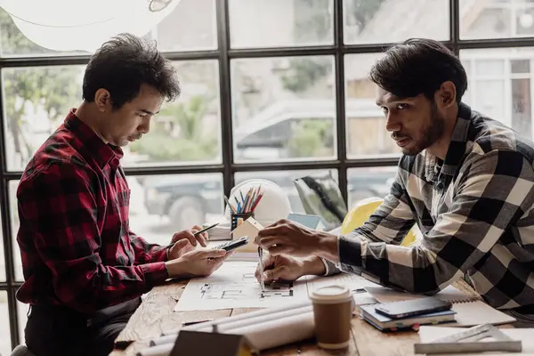 Twee Aziatische Professionele Ingenieurs Discussiëren Bouwplannen Dragen Gele Shirts Die — Stockfoto