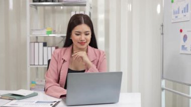 Finansal grafik belgeleriyle çalışan ve birikimleri hesaplamak için hesap makinesi kullanan genç Asyalı muhasebeci veya dizüstü bilgisayar ve vergi kopyalama, ticaret, araştırma, muhasebe belgesi, şirket 4k