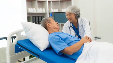 Yaşlı bir adamı yatakta muayene eden kıdemli Asyalı kadın doktor. Büyükbabasıyla ilgilenen kadın terapist. Sağlık ve sağlık sigortası.