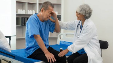 Yaşlı bir adamı yatakta muayene eden kıdemli Asyalı kadın doktor. Büyükbabasıyla ilgilenen kadın terapist. Sağlık ve sağlık sigortası.