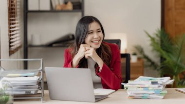 Laptop bilgisayarı kullanan Asyalı kadın ve hesap makinesi dökümanı ile ofiste çalışmak, mali raporu, iş planını, finansal yatırımı analiz etmeyi planlamak,