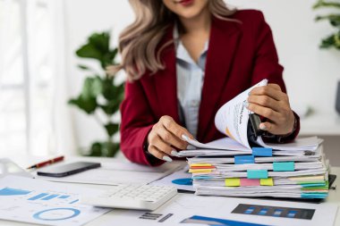 Dizüstü bilgisayarla çalışırken gülümseyen güzel Asyalı kadın muhasebeci ve finans, matematik, muhasebe raporları, istatistikler hakkında belgeler. ve araştırma fikirleri