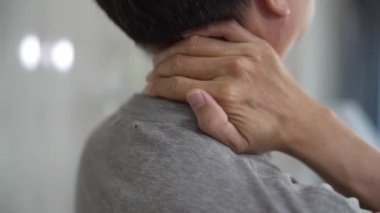 Yaşlı Asyalı adam boynuna dokunduğunda boğazı ağrır, sağlık ve emeklilik sigortası yaptırır. Hasta, yaşlı bir adamın boynunu ve sırtını germesi, İspanyolca, işkence kavramı..