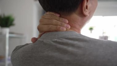 Yaşlı Asyalı adam boynuna dokunduğunda boğazı ağrır, sağlık ve emeklilik sigortası yaptırır. Hasta, yaşlı bir adamın boynunu ve sırtını germesi, İspanyolca, işkence kavramı..