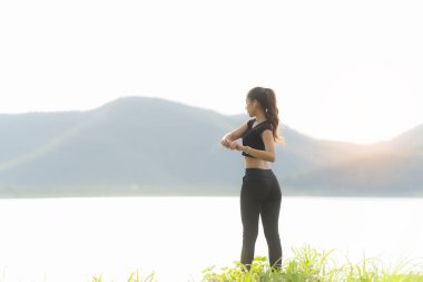 Sağlıklı genç bayan koşucu parkta koşmadan önce bacaklarını açar. Sağlık için egzersiz yapan, dışarıda koşan, insan ve yaşam tarzı, sağlık ve refah kavramı olan bir kadın. Parklarda ve dışarıda.