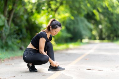 Sağlıklı genç bayan koşucu parkta koşmadan önce bacaklarını açar. Sağlık için egzersiz yapan, dışarıda koşan, insan ve yaşam tarzı, sağlık ve refah kavramı olan bir kadın. Parklarda ve dışarıda.