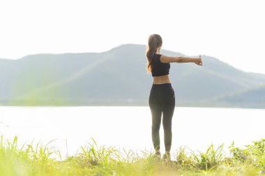 Sağlıklı genç bayan koşucu parkta koşmadan önce bacaklarını açar. Sağlık için egzersiz yapan, dışarıda koşan, insan ve yaşam tarzı, sağlık ve refah kavramı olan bir kadın. Parklarda ve dışarıda.