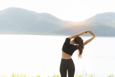 Sağlıklı genç bayan koşucu parkta koşmadan önce bacaklarını açar. Sağlık için egzersiz yapan, dışarıda koşan, insan ve yaşam tarzı, sağlık ve refah kavramı olan bir kadın. Parklarda ve dışarıda.