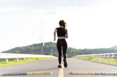 Sağlıklı genç bayan koşucu parkta koşmadan önce bacaklarını açar. Sağlık için egzersiz yapan, dışarıda koşan, insan ve yaşam tarzı, sağlık ve refah kavramı olan bir kadın. Parklarda ve dışarıda.