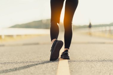 Sağlıklı genç bayan koşucu parkta koşmadan önce bacaklarını açar. Sağlık için egzersiz yapan, dışarıda koşan, insan ve yaşam tarzı, sağlık ve refah kavramı olan bir kadın. Parklarda ve dışarıda.