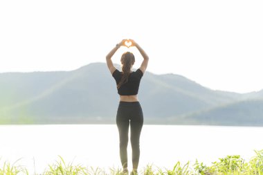 Sağlıklı bir kadın koşmadan önce ısınır ve dinlenir. Kollarını uzat ve yola bak, koşmadan önce parkta forma gir ve dışarıda sağlıklı aktivitelerin tadını çıkar..
