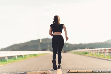 Sağlıklı bir kadın koşmadan önce ısınır ve dinlenir. Kollarını uzat ve yola bak, koşmadan önce parkta forma gir ve dışarıda sağlıklı aktivitelerin tadını çıkar..