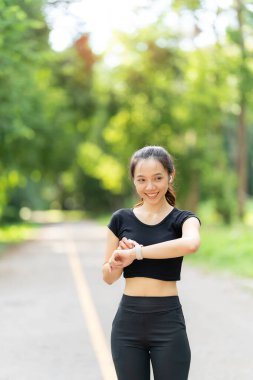Sağlıklı bir kadın koşmadan önce ısınır ve dinlenir. Kollarını uzat ve yola bak, koşmadan önce parkta forma gir ve dışarıda sağlıklı aktivitelerin tadını çıkar..