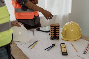 Mühendislerle ya da mimarlarla ortaklar ve mekanda modeller ve planlar yaratmak için mühendislik araçlarıyla çalıştıkları projeler için bir araya gelmek. Yakın plan resimler.