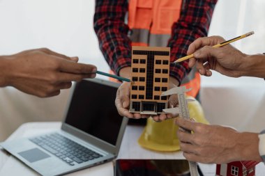 Mühendislerle ya da mimarlarla ortaklar ve mekanda modeller ve planlar yaratmak için mühendislik araçlarıyla çalıştıkları projeler için bir araya gelmek. Yakın plan resimler.