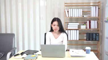 Evinde dizüstü bilgisayarlı finansal belgelerle çalışan Asyalı iş kadını pazarlamayı analiz ediyor, aylık muhasebe ve çizelgeler yapıyor. Ofiste. Evde çalış..