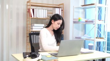 Evinde dizüstü bilgisayarlı finansal belgelerle çalışan Asyalı iş kadını pazarlamayı analiz ediyor, aylık muhasebe ve çizelgeler yapıyor. Ofiste. Evde çalış..