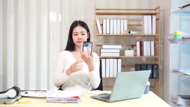 Evinde dizüstü bilgisayarlı finansal belgelerle çalışan Asyalı iş kadını pazarlamayı analiz ediyor, aylık muhasebe ve çizelgeler yapıyor. Ofiste. Evde çalış..