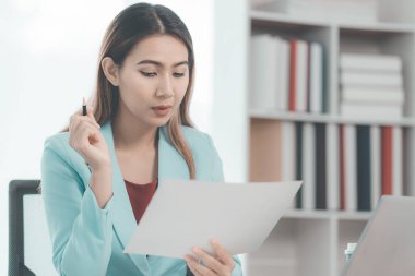 İş kadını, şirketin mali durumunu, gelirini ve bütçesini kontrol etmek için hesap makinesi kullanıyor. Aylık giderleri, kredi belgelerini hesaplıyor. Fatura