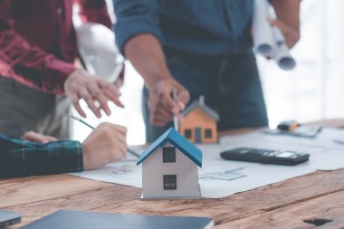 Mühendisler planların tasarlanmasına ve yapısal analizler üzerinde birlikte çalışmalarına yardım ediyorlar. Mimar İki mühendis mimari yapı taslaklarının planlarına işaret ediyor. Yakın plan resimler.