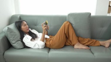 Akıllı telefon kullanan, internetten ödeme yapan, evden alışveriş yapan, e-ticaret yapan, internet bankacılığı yapan, hızlı para transferini seven, elektronik mağaza konseptini kullanan gülümseyen genç bir kadın..