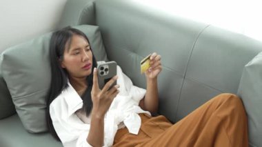 Akıllı telefon kullanan, internetten ödeme yapan, evden alışveriş yapan, e-ticaret yapan, internet bankacılığı yapan, hızlı para transferini seven, elektronik mağaza konseptini kullanan gülümseyen genç bir kadın..