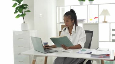 Genç Asyalı iş kadını iş prensiplerini hesaplamak için hesap makinesi kullanıyor. Yıllık mali raporun hazırlanması, hesap makinesinden alınan denetim sonuçları Gelir beyan edilen vergi oranını sayın.