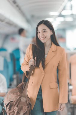 Uçuş, seyahat ve turizm konularında pencere kenarında çalışan Asyalı iş kadını, laptopla uçuş sırasında uçak kabininde çalışan başarılı Asyalı kadın.