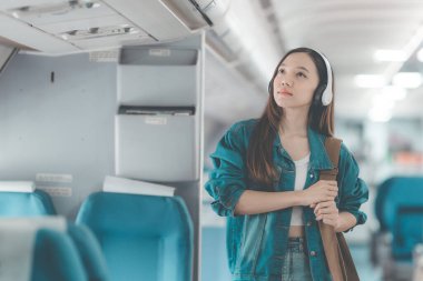 Uçuş, seyahat ve turizm konularında pencere kenarında çalışan Asyalı iş kadını, laptopla uçuş sırasında uçak kabininde çalışan başarılı Asyalı kadın.