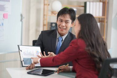 Genç Asyalı çift birlikte kutlama yapıyor. Ev ofisteki dizüstü bilgisayara bak. Küçük bir işletme kurmak için başarılı bir iş. Asyalı çift, faturaları evde tutarak bütçe veya harcamaları hesaplar.