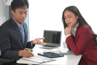 Genç Asyalı çift birlikte kutlama yapıyor. Ev ofisteki dizüstü bilgisayara bak. Küçük bir işletme kurmak için başarılı bir iş. Asyalı çift, faturaları evde tutarak bütçe veya harcamaları hesaplar.