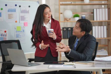 Genç Asyalı çift birlikte kutlama yapıyor. Ev ofisteki dizüstü bilgisayara bak. Küçük bir işletme kurmak için başarılı bir iş. Asyalı çift, faturaları evde tutarak bütçe veya harcamaları hesaplar.