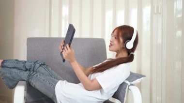 Asyalı kız tabletinde, laptopunda, oyun ve sosyal medyada veya arkadaşlarıyla sohbet ederken sosyal medyayı kullanmaktan hoşlanıyor.