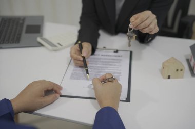 Müşteriler ve çalışanlar malzemelere bakarak materyalleri tartışıyor. Ev ve ev sigortası satma, ev satın alma veya satış sözleşmesi, konut kirası, emlak sigortası