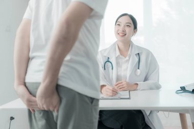 Tedavisi hakkında bir doktora danışmak için bir adamın elinde hemoroit vardır. Sağlık hizmeti kavramı.