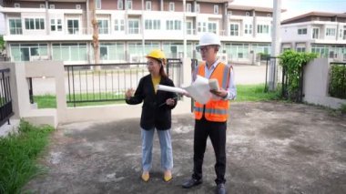 Asyalı emlak işadamı konut projesini teftiş ediyor. Genç bir çift ev inşaatının planını tartışıyor ve inceliyor..