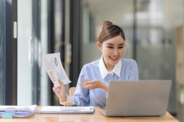 İş yerindeki bilgisayar ve mali belgeleri kullanarak iş verilerini hesaplayan Asyalı kadın çalışanlar, harcamalardaki muhasebe belgelerini kontrol ediyorlar. Finansal muhasebe kavramı.