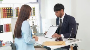 İki erkek ve kadın avukat sözleşmeleri ve anlaşma kavramlarını tartışıyor. Müvekkillerle istişarede bulunan avukatlar gayrimenkul ve finans hukuku hakkında konuşuyorlar