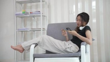 İnternetten akıllı telefondan alışveriş yapan Asyalı bir kadın uygulamadan sipariş vermiş ve ürünü kredi kartıyla ödemiş..