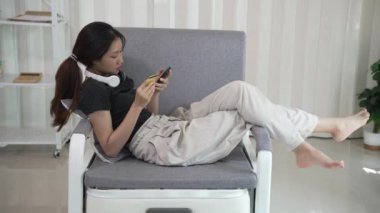 İnternetten akıllı telefondan alışveriş yapan Asyalı bir kadın uygulamadan sipariş vermiş ve ürünü kredi kartıyla ödemiş..