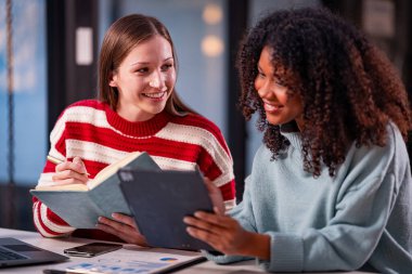 İki kadın yeni proje fikirlerinin sunumu, pazarlama planları ve başarılı olması için iş yatırımlarını tartışır, tartışır, tartışır, çalışır..