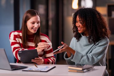 İki kadın yeni proje fikirlerinin sunumu, pazarlama planları ve başarılı olması için iş yatırımlarını tartışır, tartışır, tartışır, çalışır..
